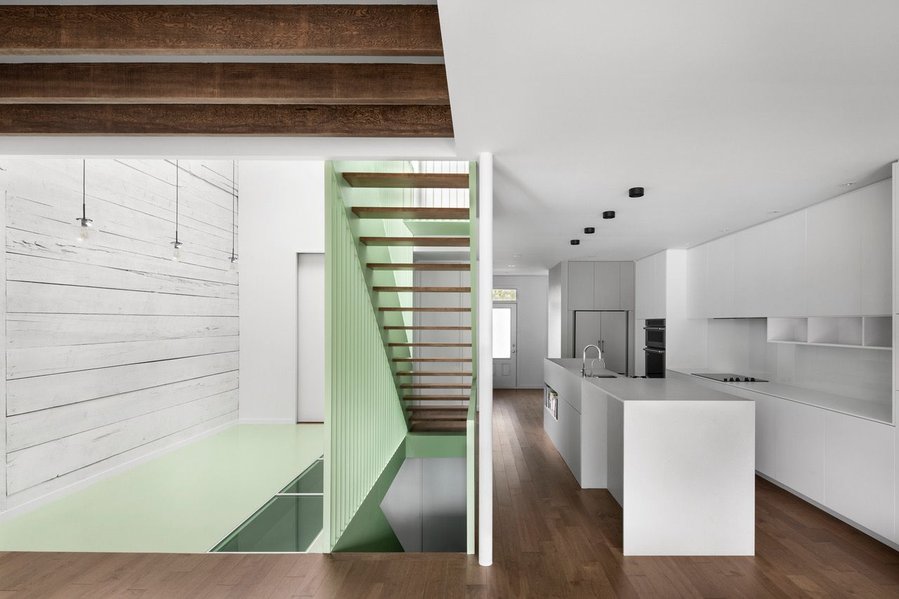 A lovely mint green staircase sits at the heart of the renovated Victoria Residence.