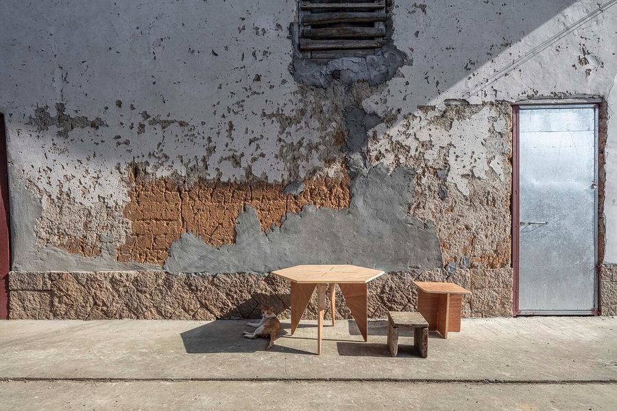 A simple plywood table and chairs sit just aorund the corner from the site of the pavilion in rural Fuqing, China.