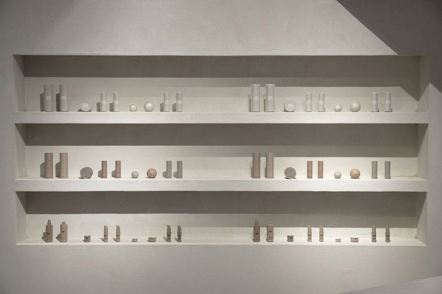 Minimalist concrete shelves display luxury skincare products inside Kim Kardashian's SKKN pop-up store.