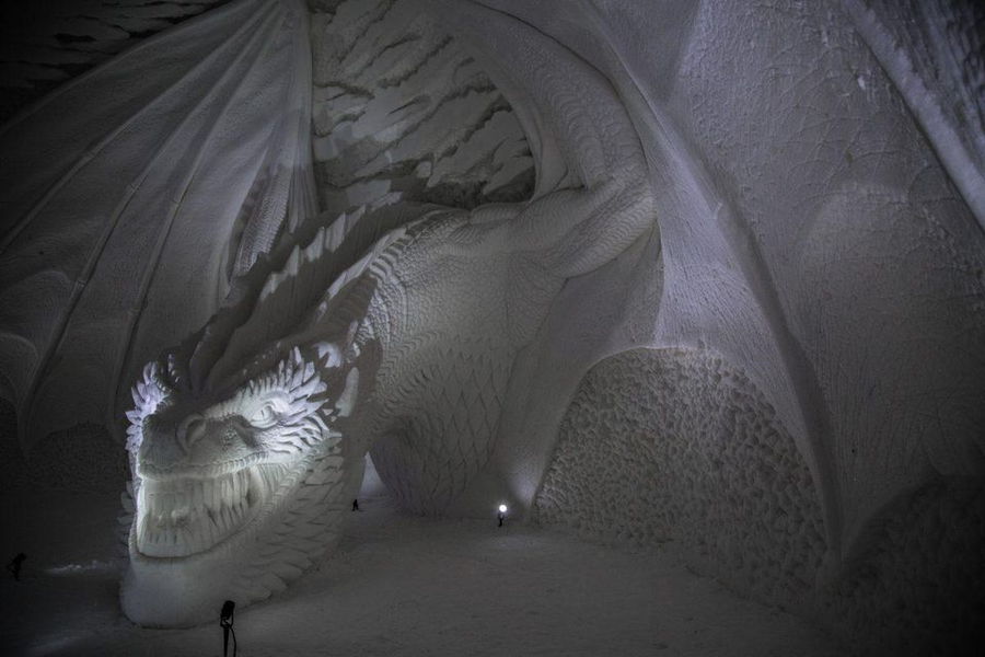 An enormous snow dragon bares his teeth inside the halls of Lapland Hotels SnowVillage 