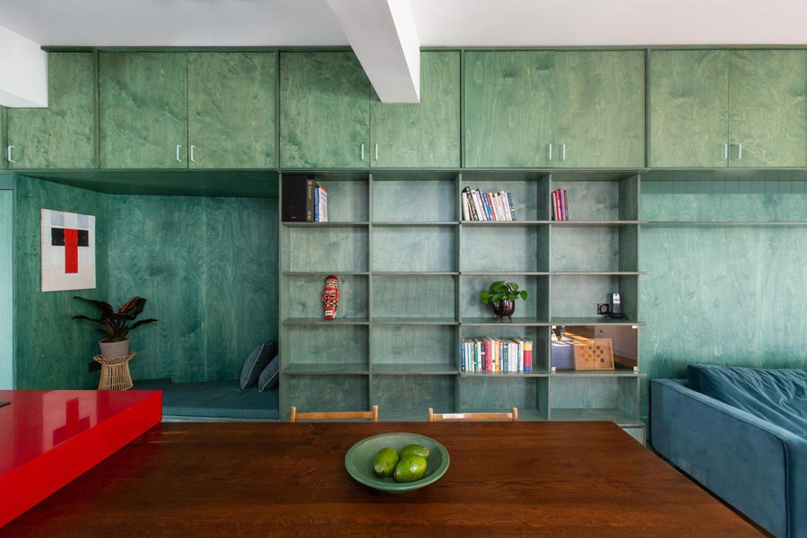 Turquoise shelves and cabinets run all along the interiors of the Point Supreme-renovated apartment.