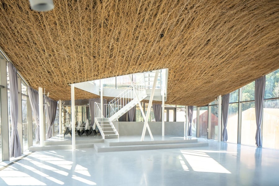 Woven grass canopy extends over the interior parts of the Flowing Cloud pavilion.