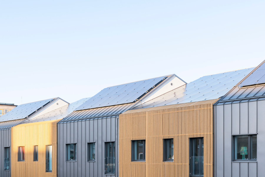 Solar panels line the length of each prefab row house's roof. 