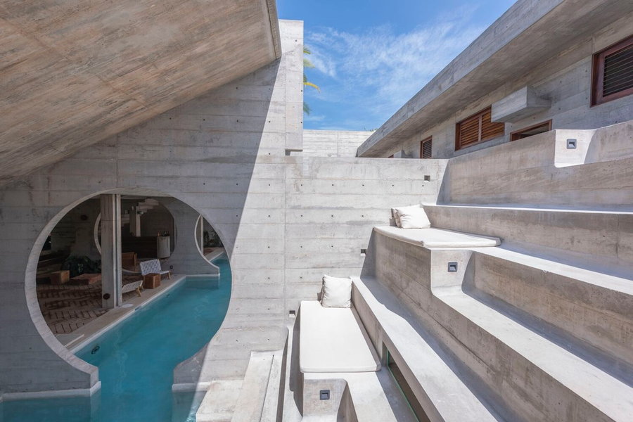 Stepped concrete lounge spaces sit alongside the Casa TO's infinity pool.