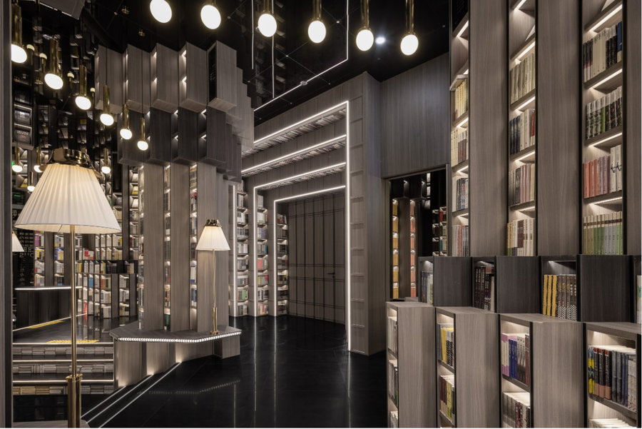 Warm, lit-up forum room in the Shenzhen Zhongshuge bookstore uses stepped bookshelves to form a 