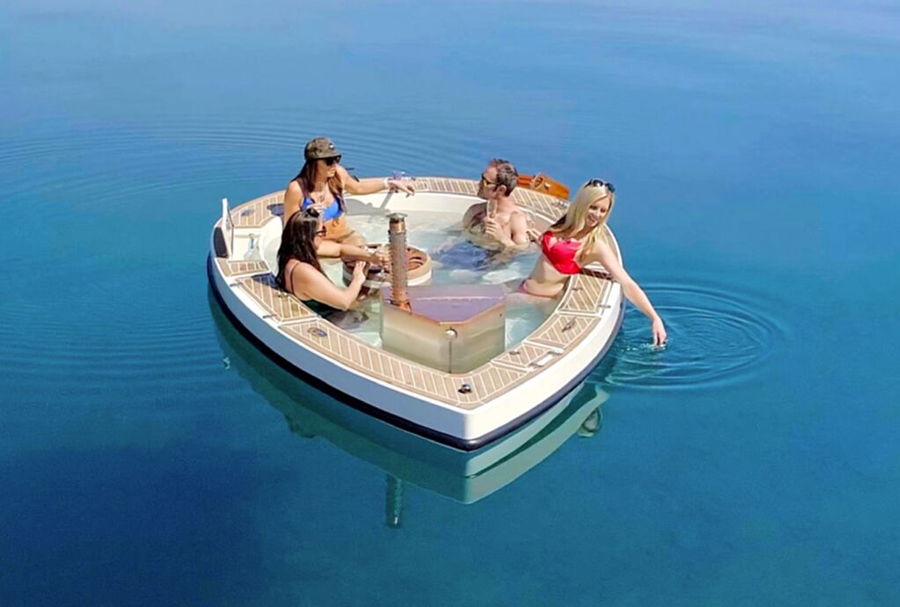 Friends enjoy drinks on the lake from the comfort of the Spracuzzi floating hot tub. 