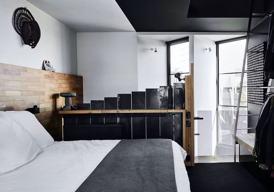 Airy black and white bedroom inside the Splinter Society architects' spiky black home in Melbourne.
