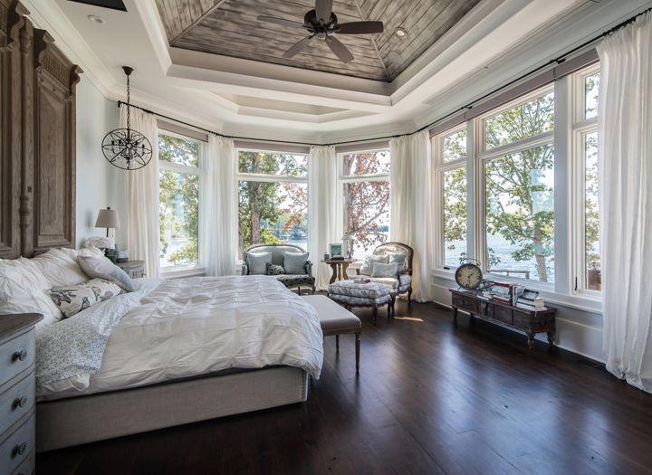 A large Victorian-style bedroom adorned with lots of white decor pieces and sleek hanging fixtures. 
