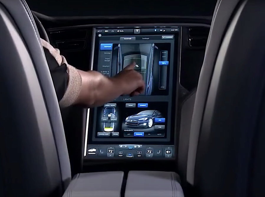 Tesla driver operates controls from the vehicle's touchscreen infotainment center.