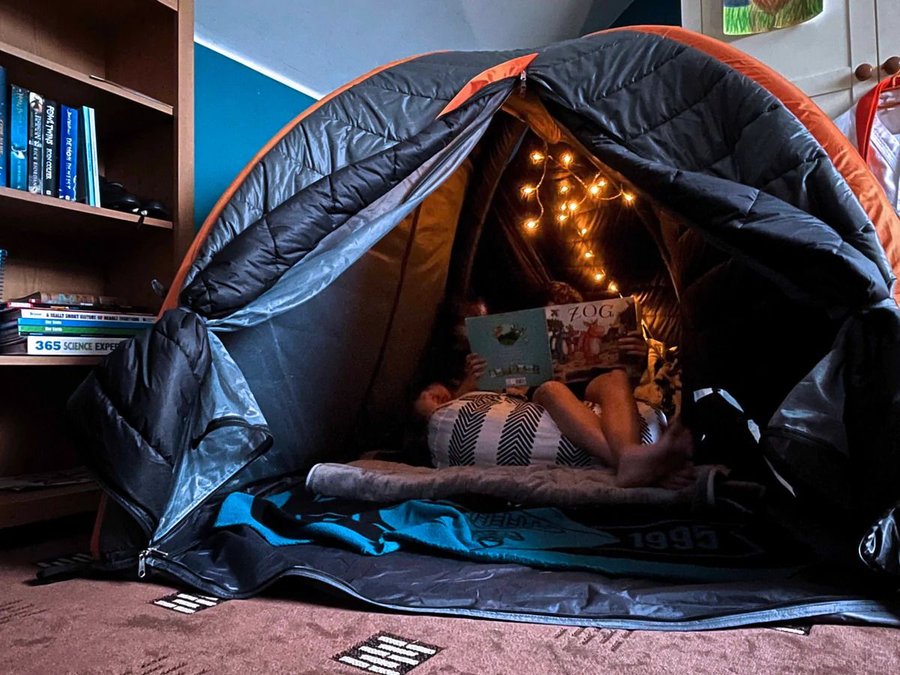 Children read a book on a bean bag chair inside Crua's Crucoon insulated inflatable tent.