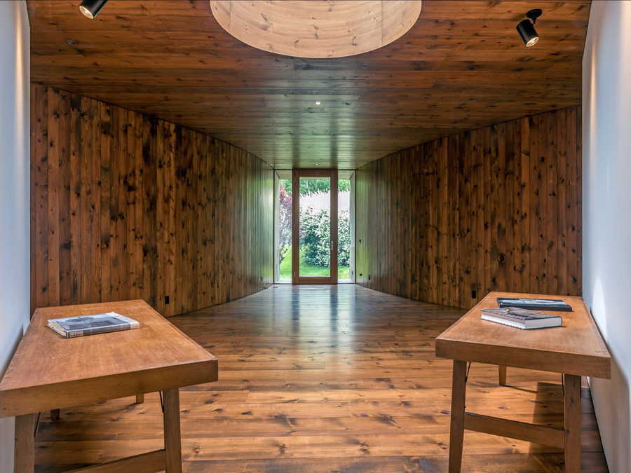The interiors of the guest house are elegantly clad in stained wood, with minimal furniture around to interfere.