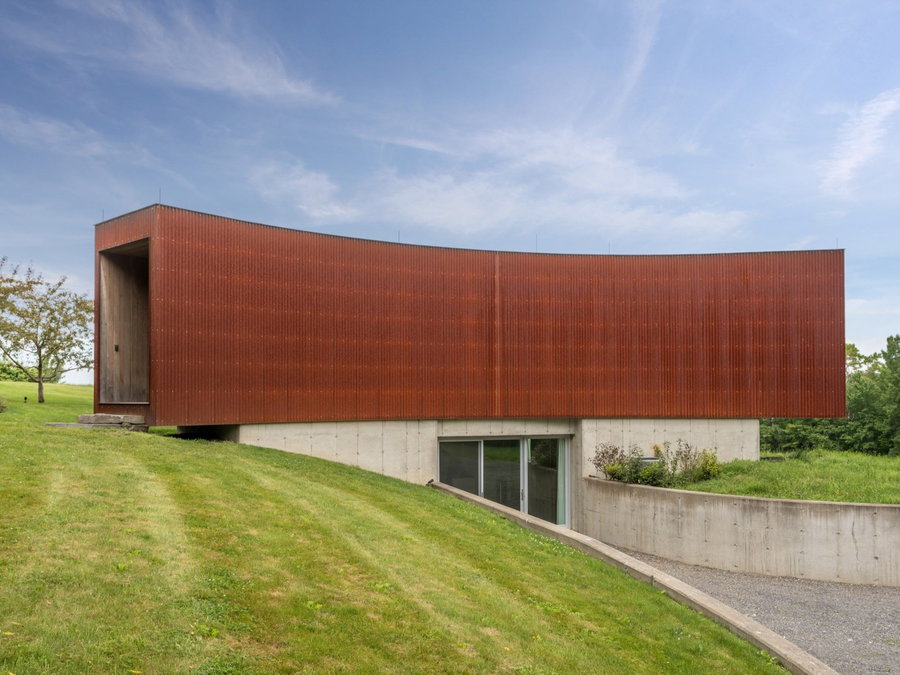 The guest house of the Tsai Residence is clad in a rusted Corten steel, and comes complete with a sunken walkway.