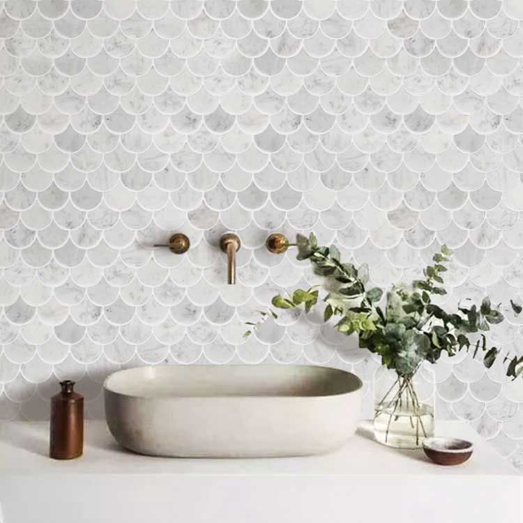 Ornate mermaid tiles adorn a bathroom wall.