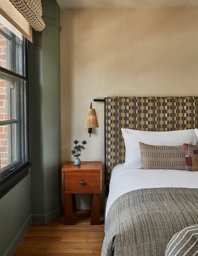 Warm, wooden nightstand near a soft, neutral bed.