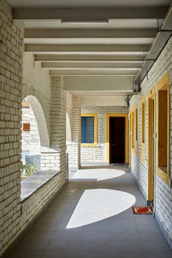 Covered outdoor walkway runs along the unit entrances of the CDA's revitalized Sanjaynagar housing units.