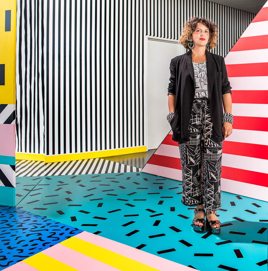 Designer and artist Camille Walala stands in the middle of one of her vibrant designs. 