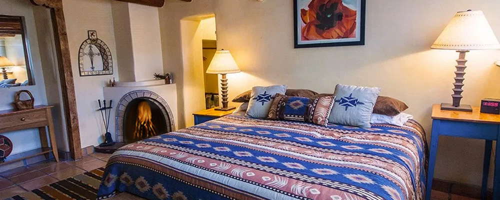 Comanche suite boasts plenty of room with comfortable king bed, closet butler,  and real wood burning kiva fireplace! Livingroom, 50" flat screen wall mounted tv, small full kitchen not shown.