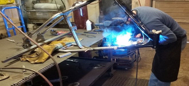person welding a metal frame