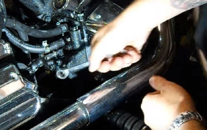 Use a 7/16" box or ratcheting wrench to remove the four bolts on the front half of the oil pump