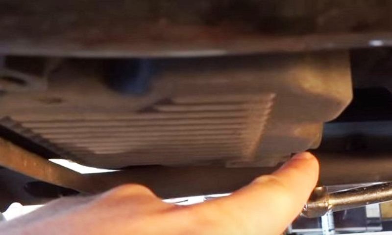 Locate the oil drain plug and remove to drain the oil into your catch basin