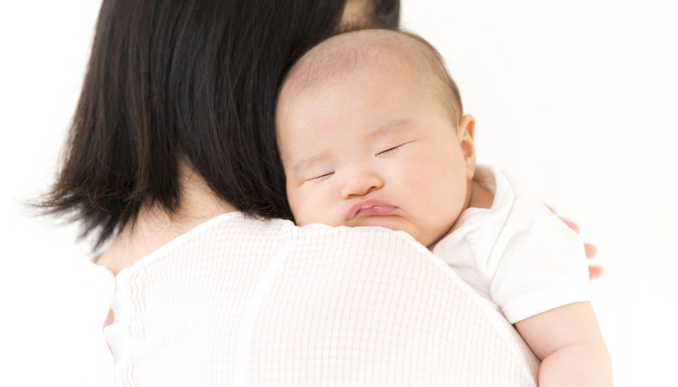 mother burping baby over her shoulder