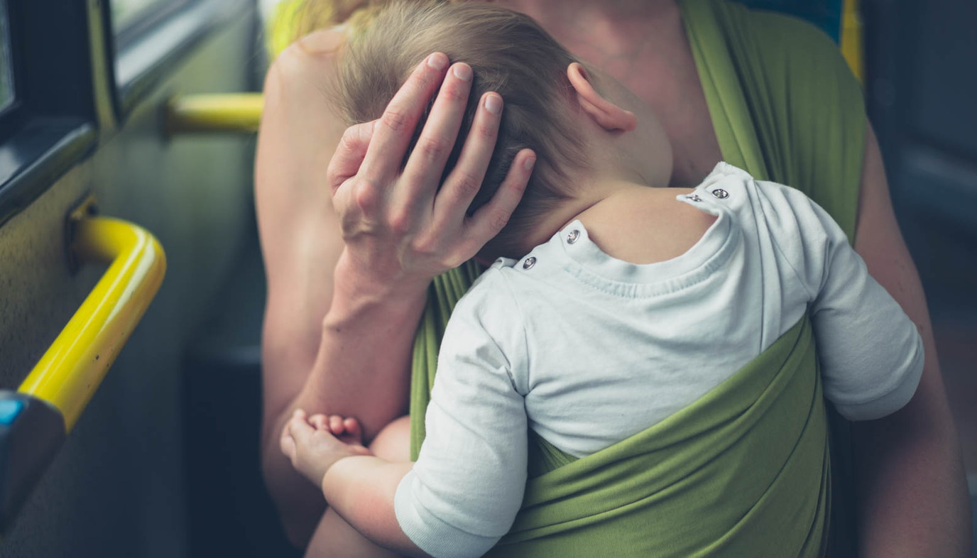 Mother breastfeeding baby on bus