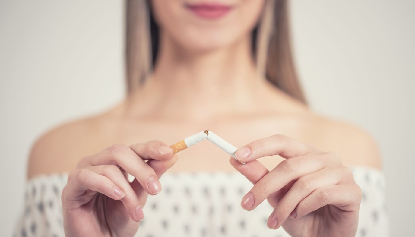 woman breaking a cigarette in half