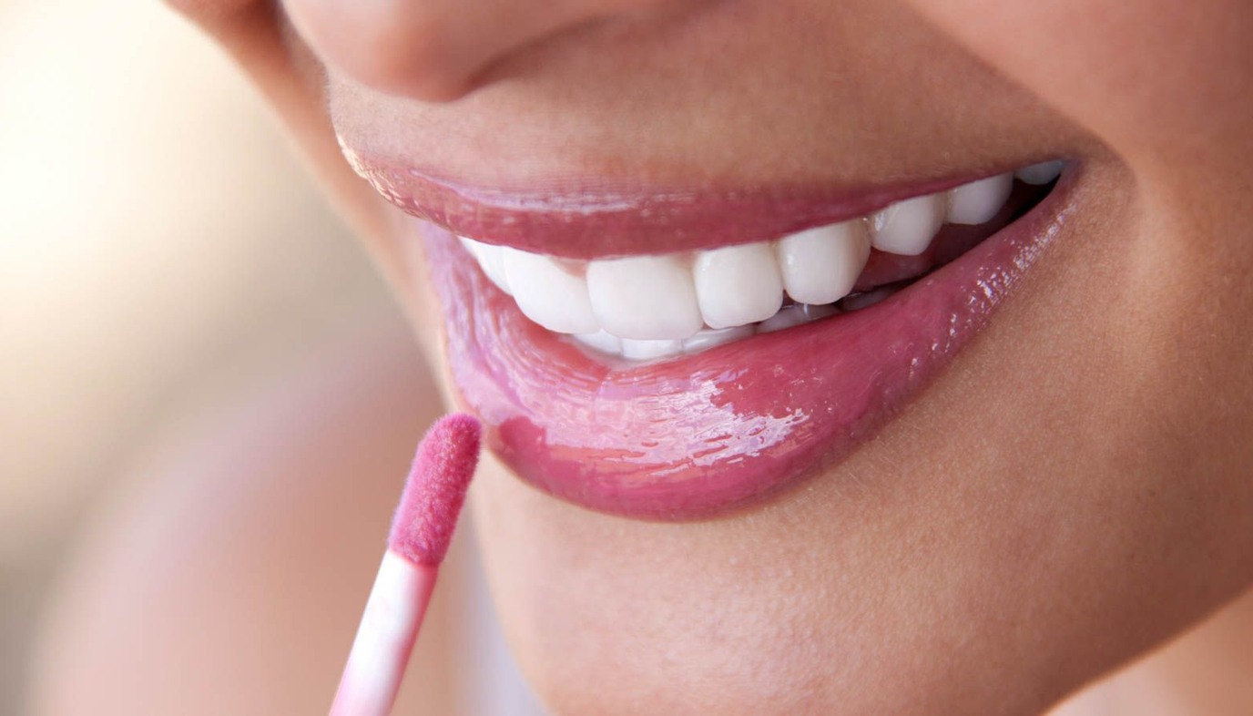 woman applying lip gloss