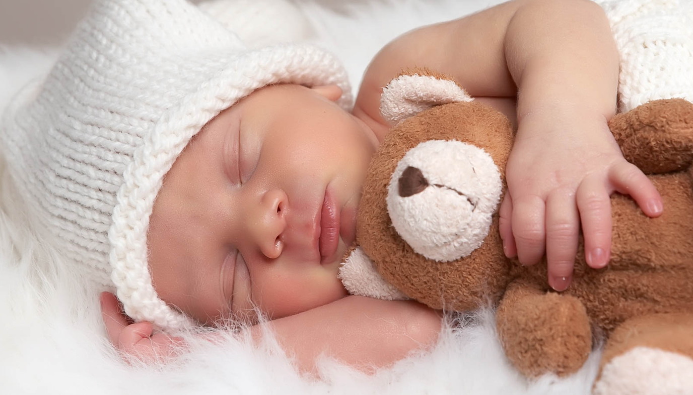 baby sleeping with teddy bear