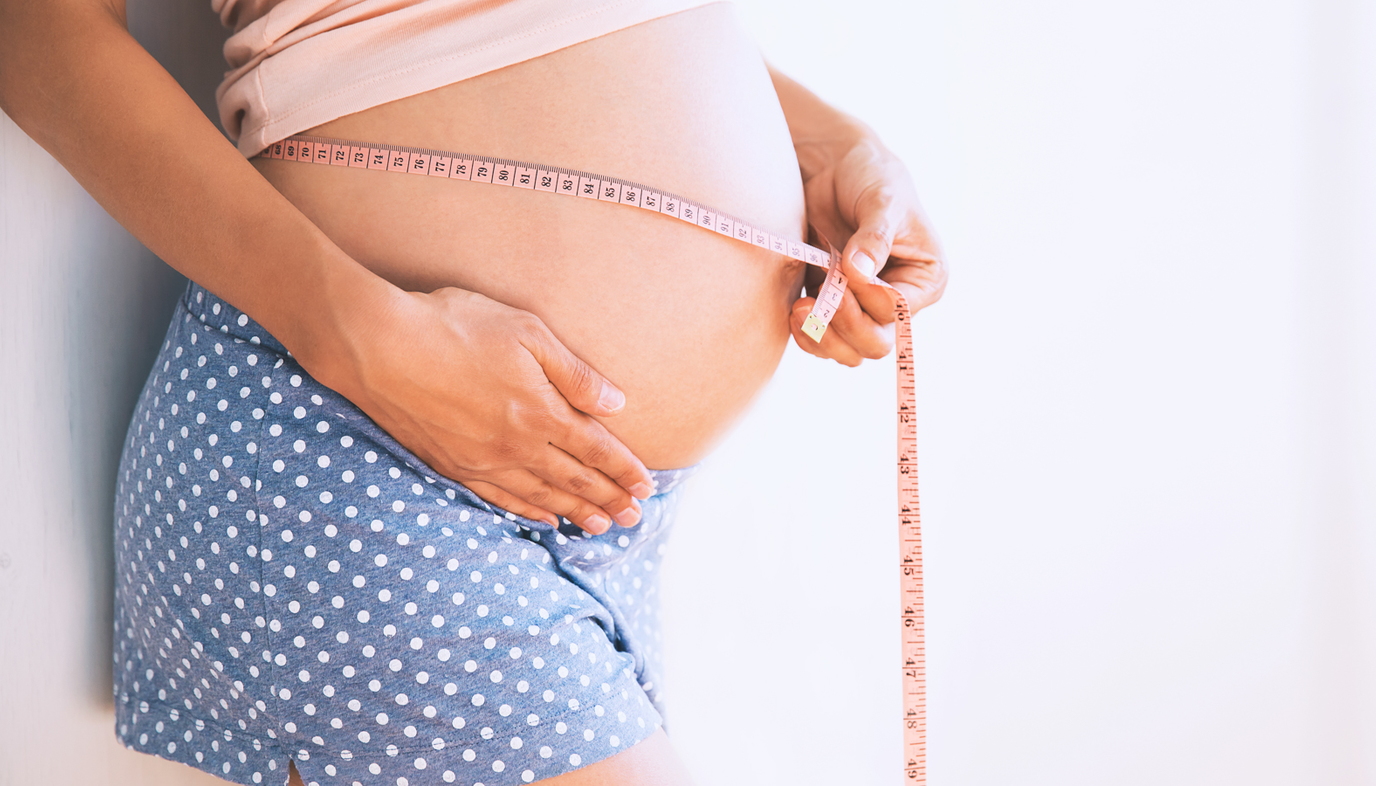 measuring tape around pregnant belly