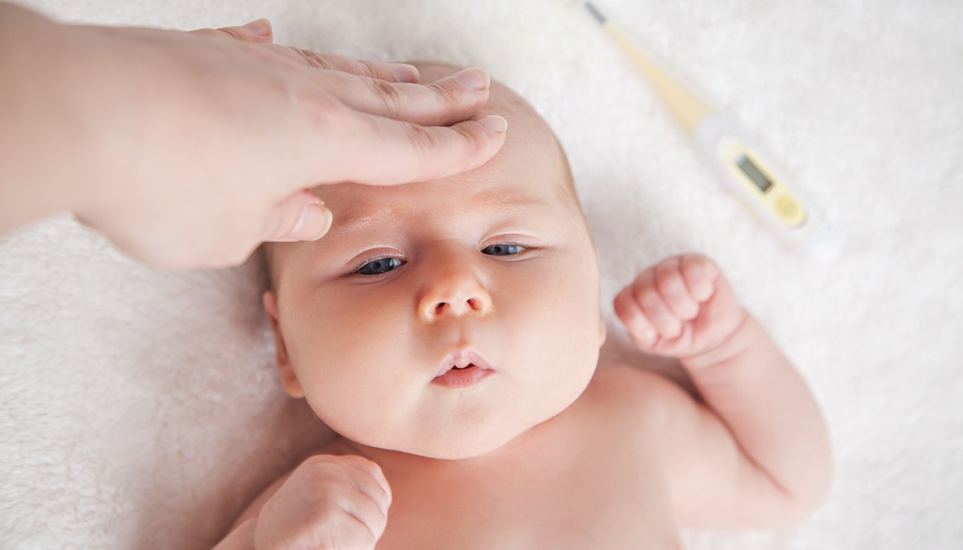 mom feeling baby's head to check for fever