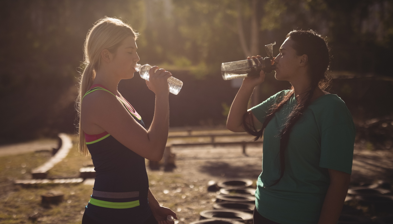 women drinking water after workout