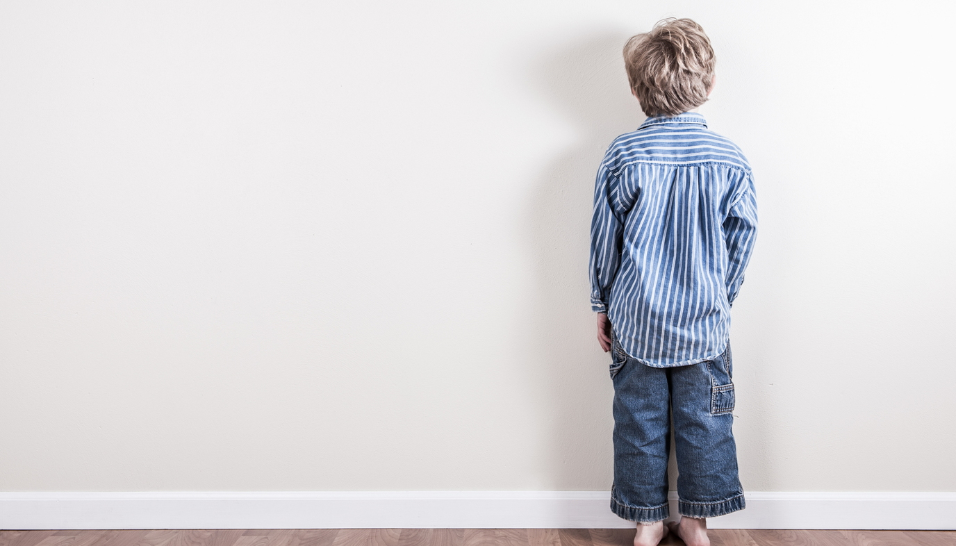 boy standing against the wall