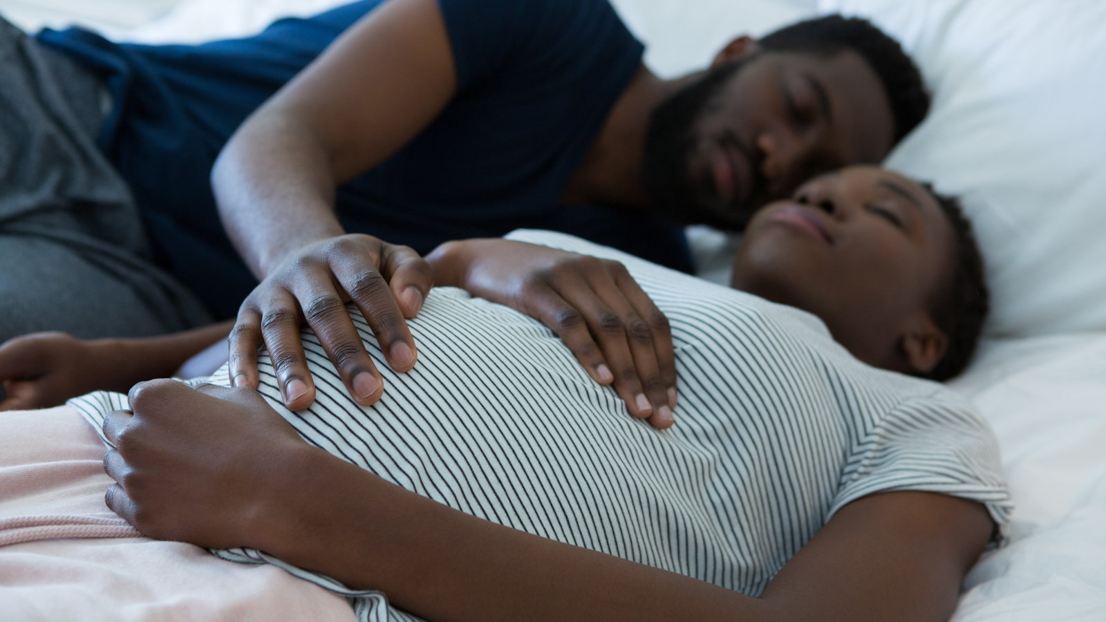 pregnant woman sleeping with husband