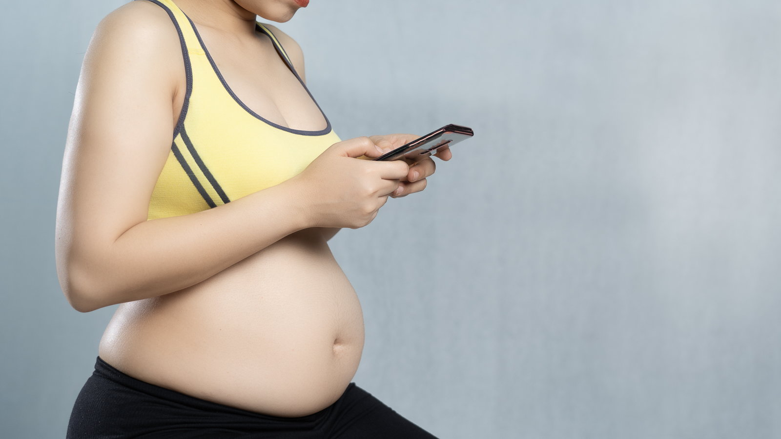 pregnant mom in sports top using app