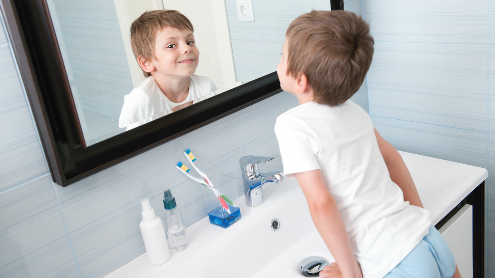 child looking in bathroom mirror