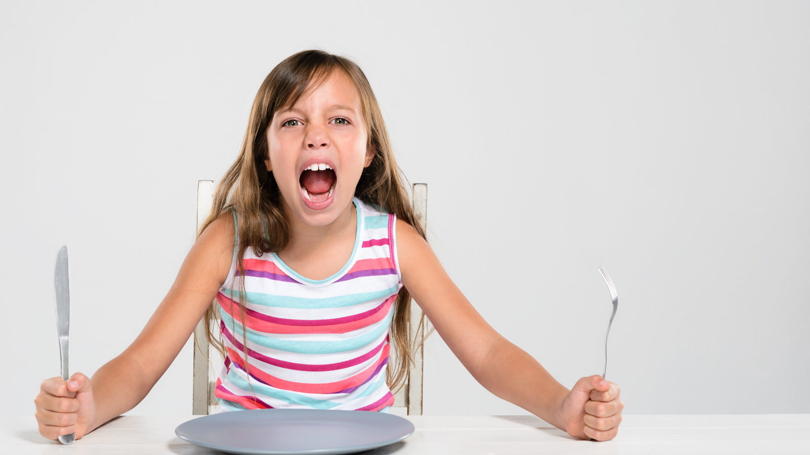 girl screaming for food at dinner table