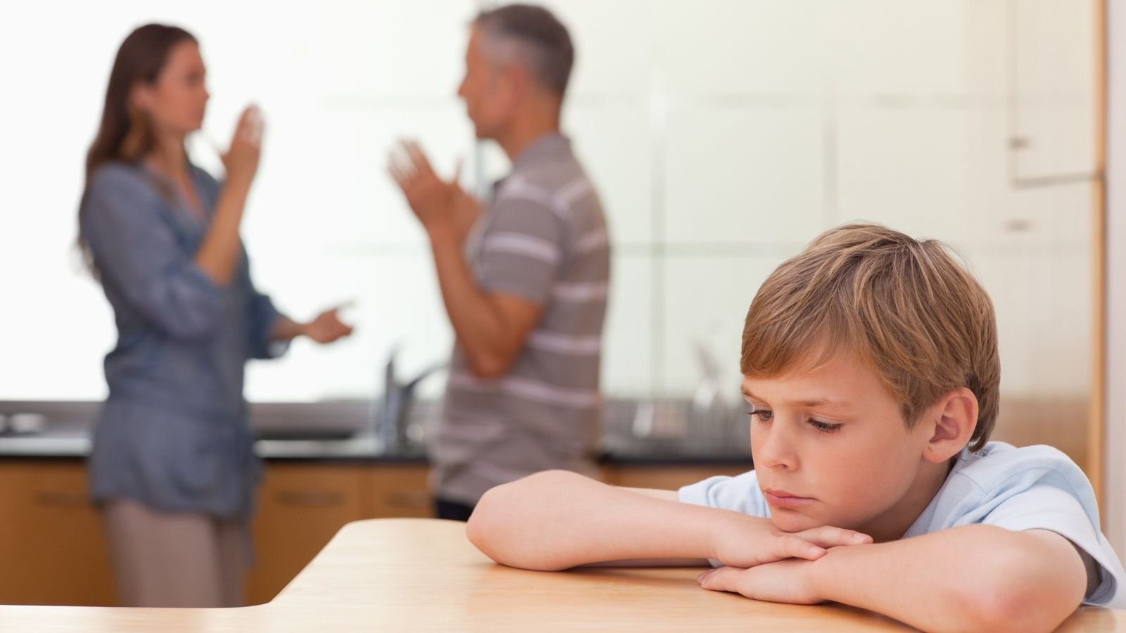 sad boy listening to parents fighting