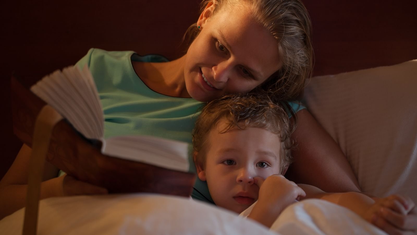 mom reading book to child