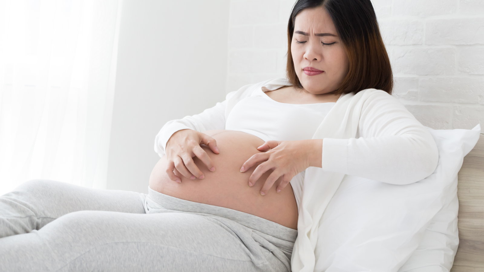 woman scratching pregnant belly