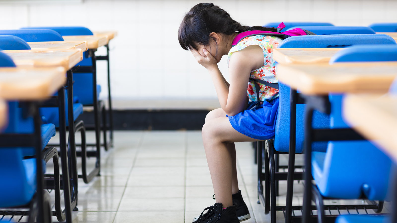 sad child in empty classroom