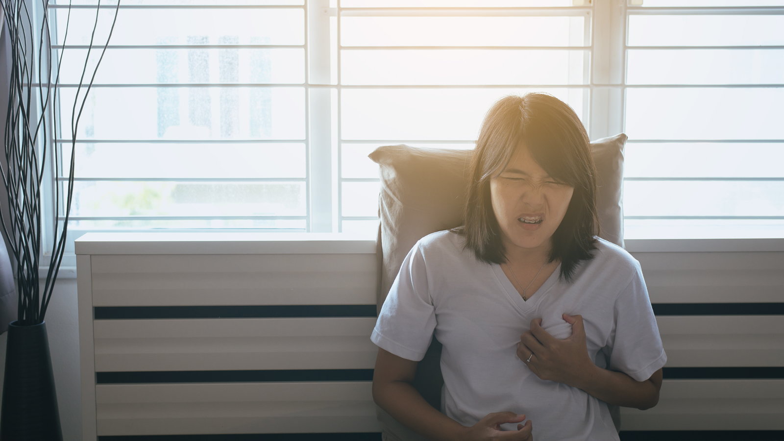 woman clutching chest in pain