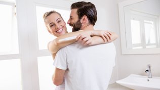 excited woman with pregnancy test 4 weeks pregnant
