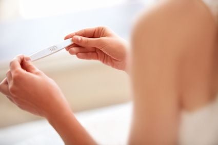 woman reading pregnancy test