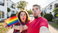 man and woman holding rainbow flag