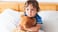 child holding teddy bear in bed