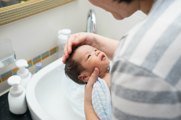 Someone giving a baby a sponge bath. 