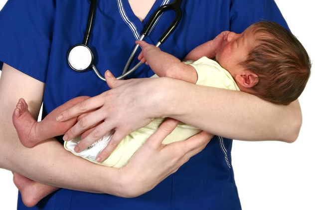 A nurse holding a newborn. 