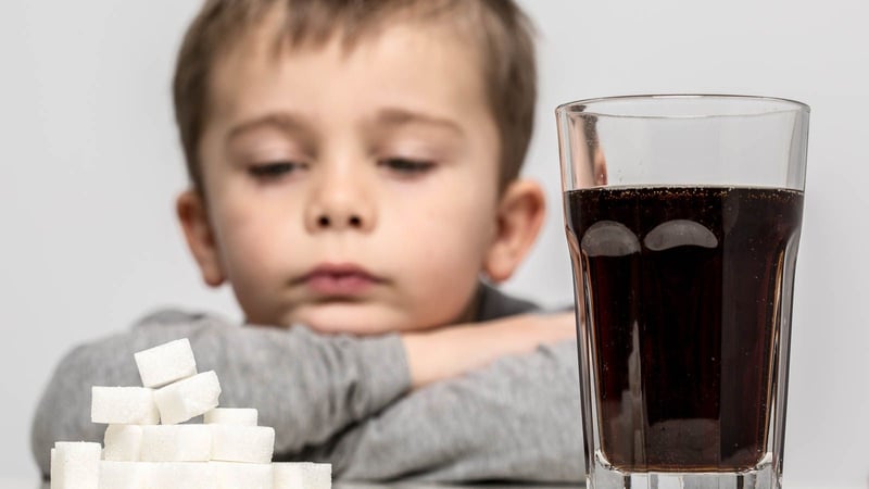 boy looking at sugar cubes and a cup of soda