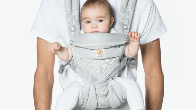 Dad babywearing in a soft structured Ergo carrier.